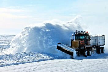 A large truck removing snow from a road